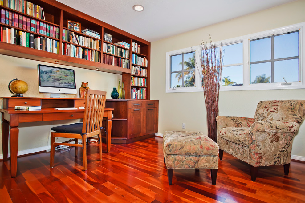 Foto de despacho de estilo americano con paredes beige, suelo de madera oscura y escritorio independiente