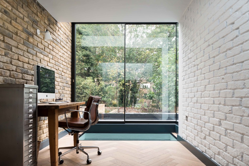 Cette image montre un bureau design de taille moyenne avec parquet clair, un bureau indépendant et un sol beige.