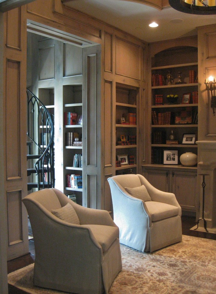 Example of a large classic dark wood floor and brown floor home office library design in Houston with beige walls