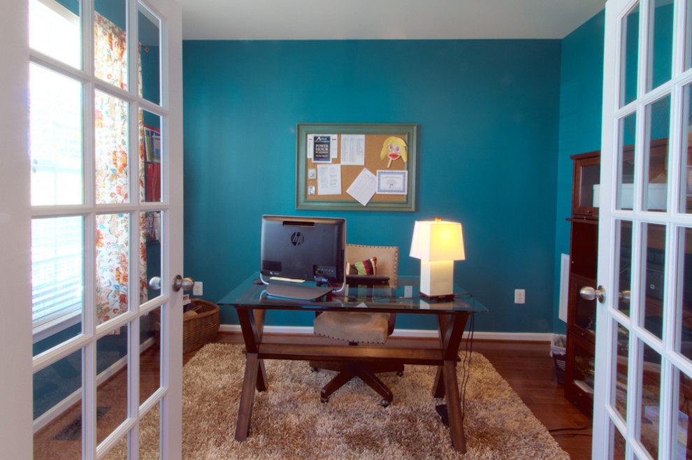 Immagine di un ufficio minimal con pareti blu, pavimento in legno massello medio e scrivania autoportante