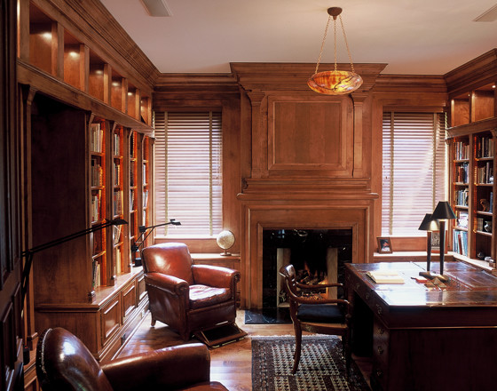 Стильный дизайн: домашняя библиотека в классическом стиле с паркетным полом среднего тона, стандартным камином, фасадом камина из дерева и отдельно стоящим рабочим столом - последний тренд