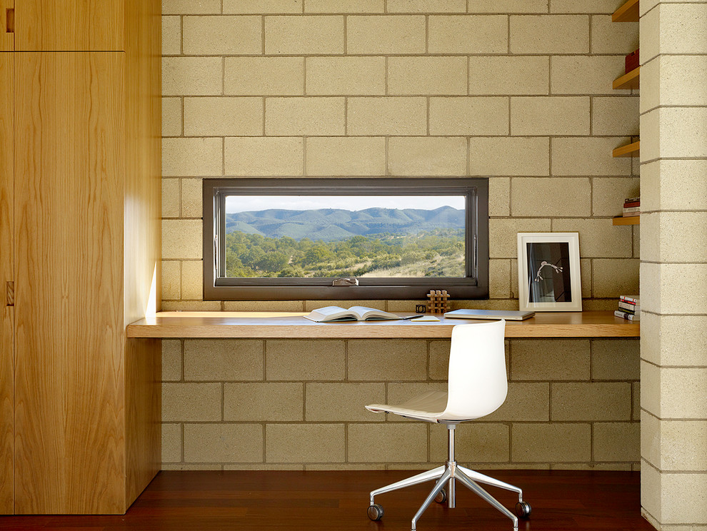 Exempel på ett modernt arbetsrum, med mörkt trägolv och ett inbyggt skrivbord