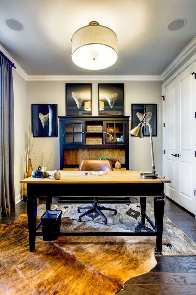 На фото: рабочее место в стиле неоклассика (современная классика) с серыми стенами, темным паркетным полом, отдельно стоящим рабочим столом и коричневым полом