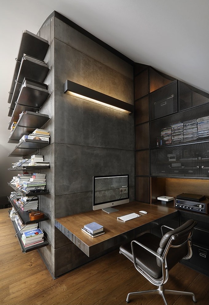 Imagen de despacho industrial con suelo de madera oscura y escritorio empotrado