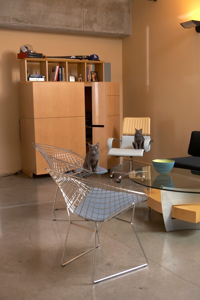 Идея дизайна: большая домашняя мастерская в современном стиле с коричневыми стенами, бетонным полом и отдельно стоящим рабочим столом без камина
