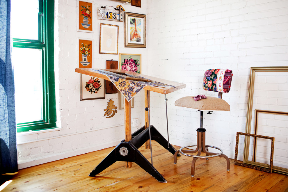 Inspiration för ett eklektiskt hemmastudio, med vita väggar, mellanmörkt trägolv och ett fristående skrivbord