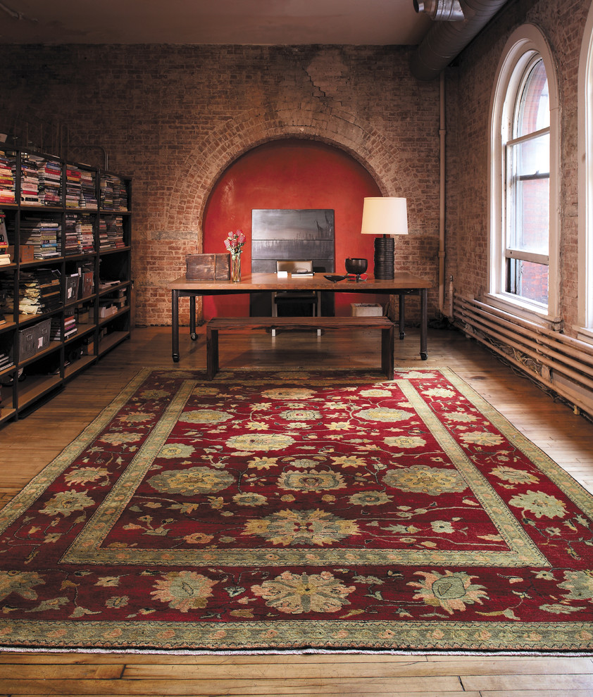 Imagen de despacho ecléctico sin chimenea con suelo de madera clara, escritorio independiente y paredes rojas
