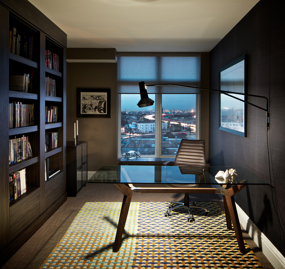 На фото: рабочее место среднего размера в стиле модернизм с коричневыми стенами, темным паркетным полом и отдельно стоящим рабочим столом без камина с
