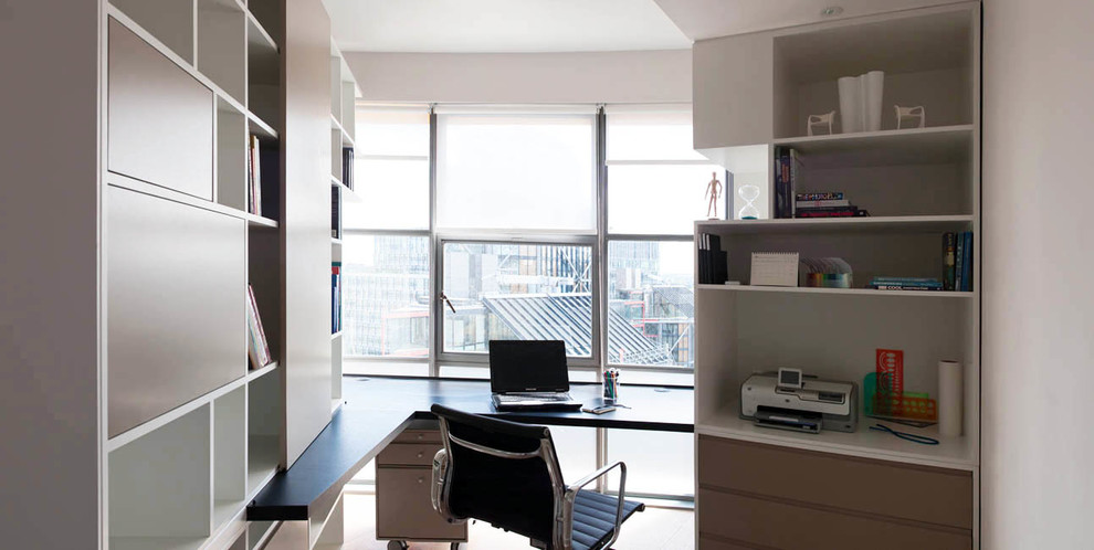 Réalisation d'un bureau design de type studio avec un mur blanc, parquet clair et un bureau intégré.