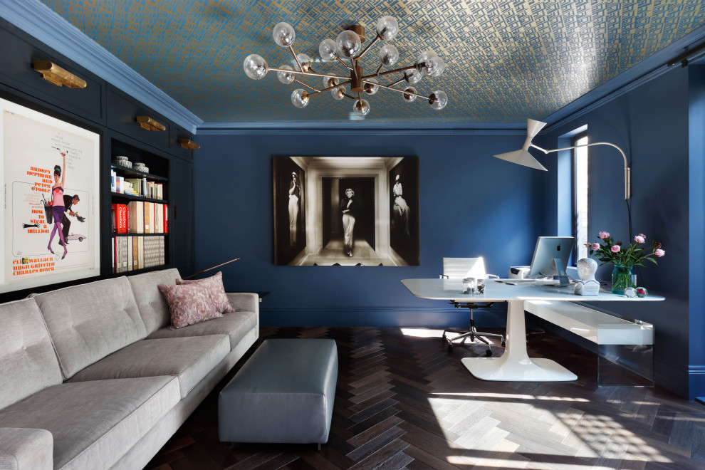 Large contemporary study in London with blue walls, dark hardwood flooring, a freestanding desk and brown floors.