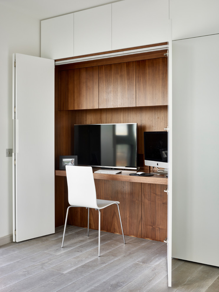Immagine di un piccolo ufficio moderno con scrivania incassata, pareti bianche e pavimento grigio