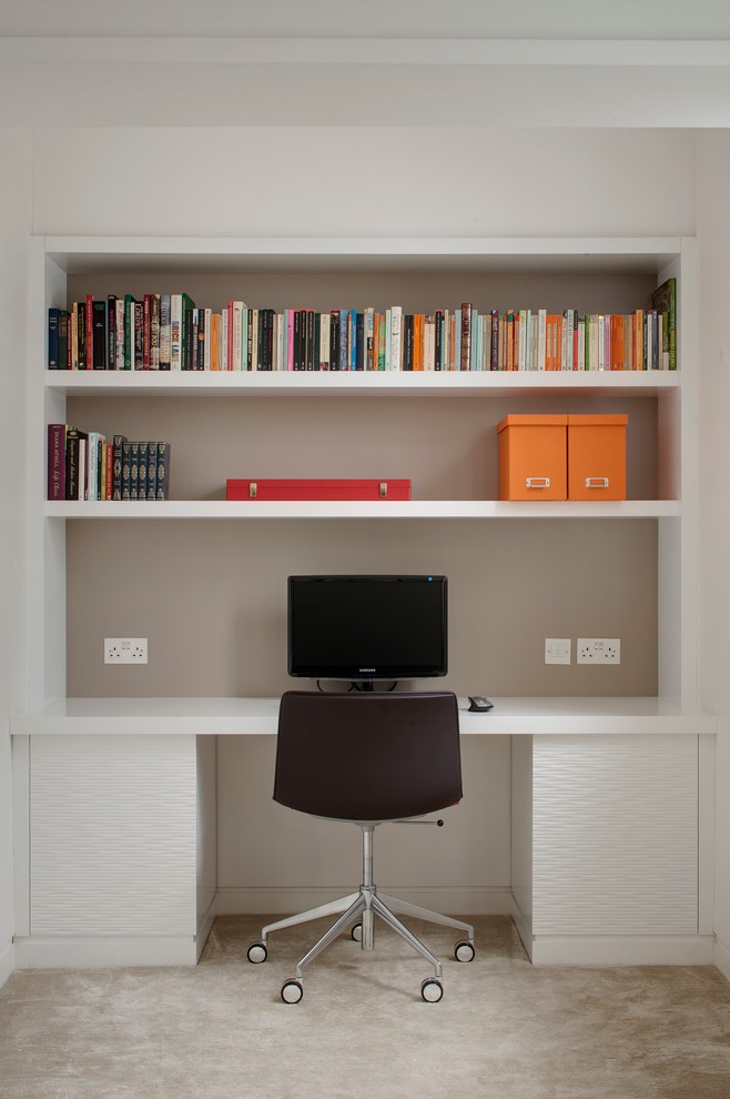 На фото: кабинет в современном стиле с серыми стенами, ковровым покрытием и встроенным рабочим столом без камина