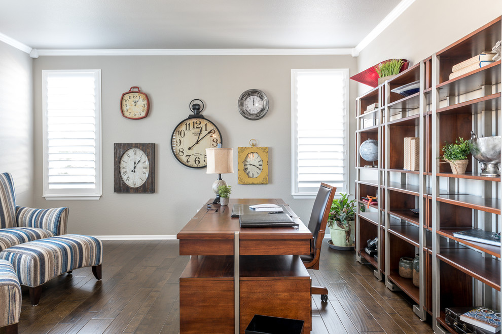 This is an example of a classic study in Denver with beige walls, dark hardwood flooring, a freestanding desk and brown floors.