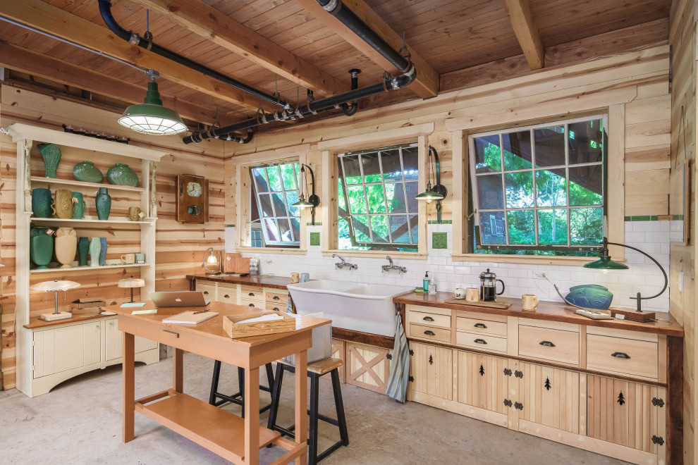 Imagen de despacho de estilo de casa de campo con paredes beige, suelo de cemento, escritorio independiente, suelo gris, vigas vistas, madera y madera