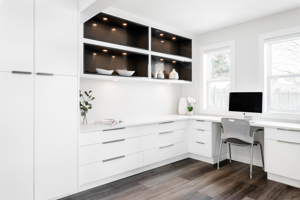 Réalisation d'un bureau minimaliste de taille moyenne avec un mur blanc, un sol en vinyl, une cheminée standard, un manteau de cheminée en plâtre, un bureau intégré et un sol marron.