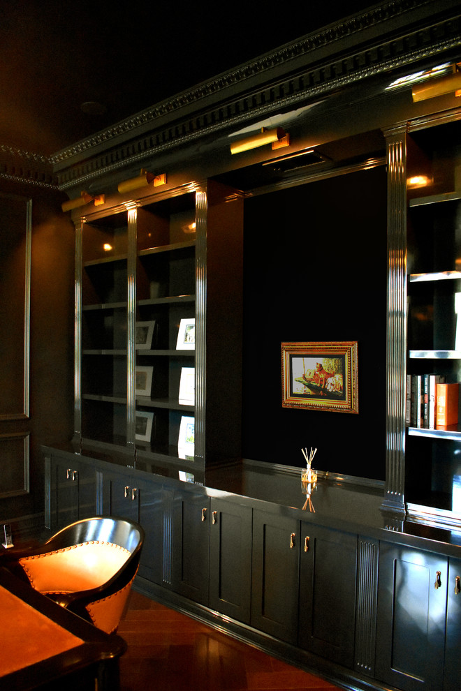 Cette image montre un bureau design de taille moyenne avec une bibliothèque ou un coin lecture, un mur noir, parquet foncé et un bureau indépendant.