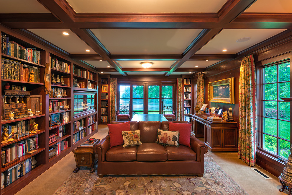 На фото: большой домашняя библиотека в классическом стиле с отдельно стоящим рабочим столом, коричневыми стенами и ковровым покрытием без камина
