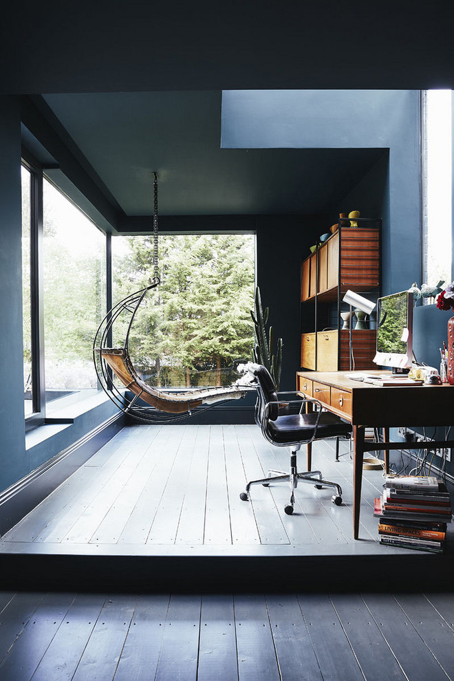 На фото: большое рабочее место в современном стиле с синими стенами, деревянным полом, отдельно стоящим рабочим столом и синим полом