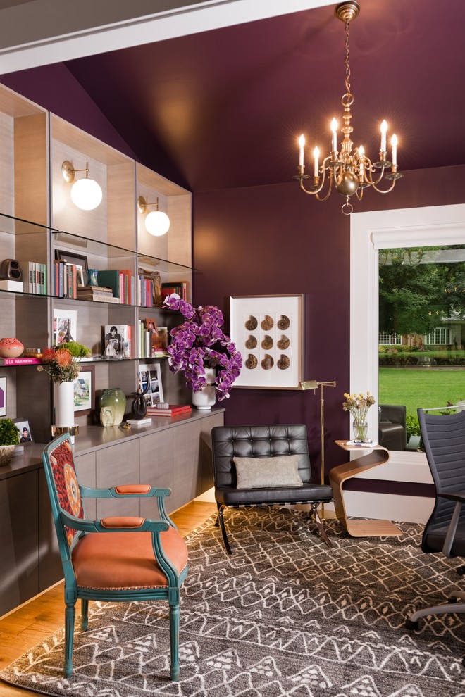 Cette photo montre un bureau éclectique avec un mur violet et un sol en bois brun.