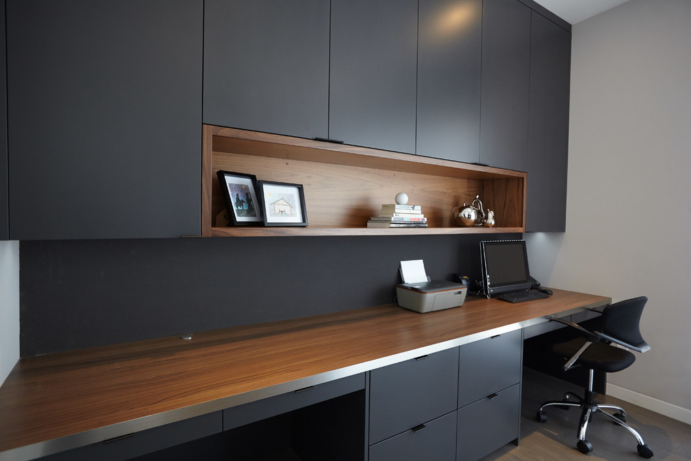 Exemple d'un bureau moderne de taille moyenne avec un mur gris, un sol en bois brun, aucune cheminée et un bureau intégré.