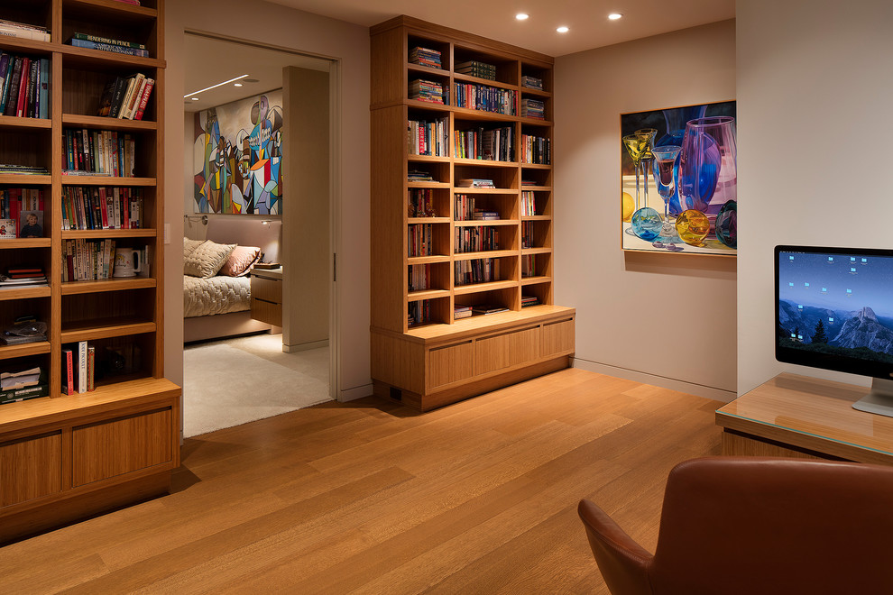 Источник вдохновения для домашнего уюта: домашняя библиотека среднего размера в современном стиле с серыми стенами, паркетным полом среднего тона, отдельно стоящим рабочим столом и коричневым полом без камина