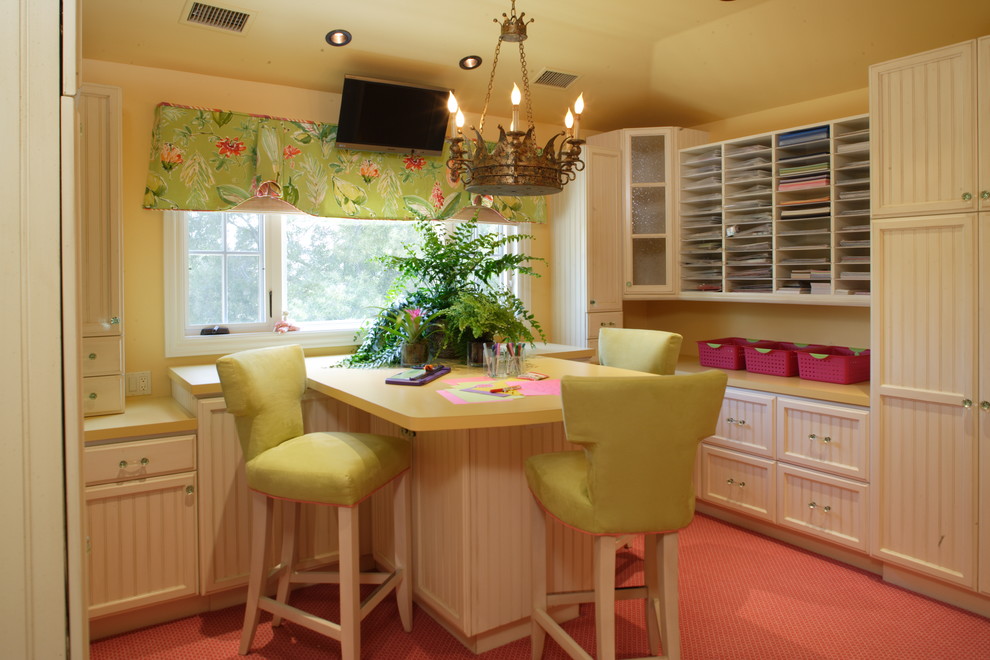 На фото: большой кабинет в классическом стиле с местом для рукоделия, желтыми стенами, ковровым покрытием, встроенным рабочим столом и розовым полом с