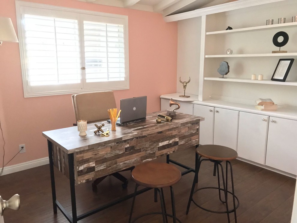 Example of a mid-sized transitional freestanding desk dark wood floor and brown floor study room design in Orange County with pink walls and no fireplace