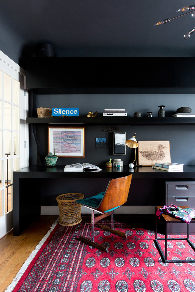 Modernes Arbeitszimmer mit Arbeitsplatz, grauer Wandfarbe, braunem Holzboden, Einbau-Schreibtisch und braunem Boden in Sonstige