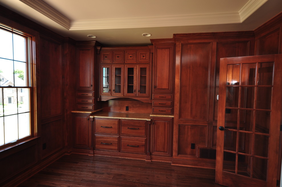 Foto de despacho tradicional grande sin chimenea con paredes marrones, suelo de madera en tonos medios y escritorio independiente