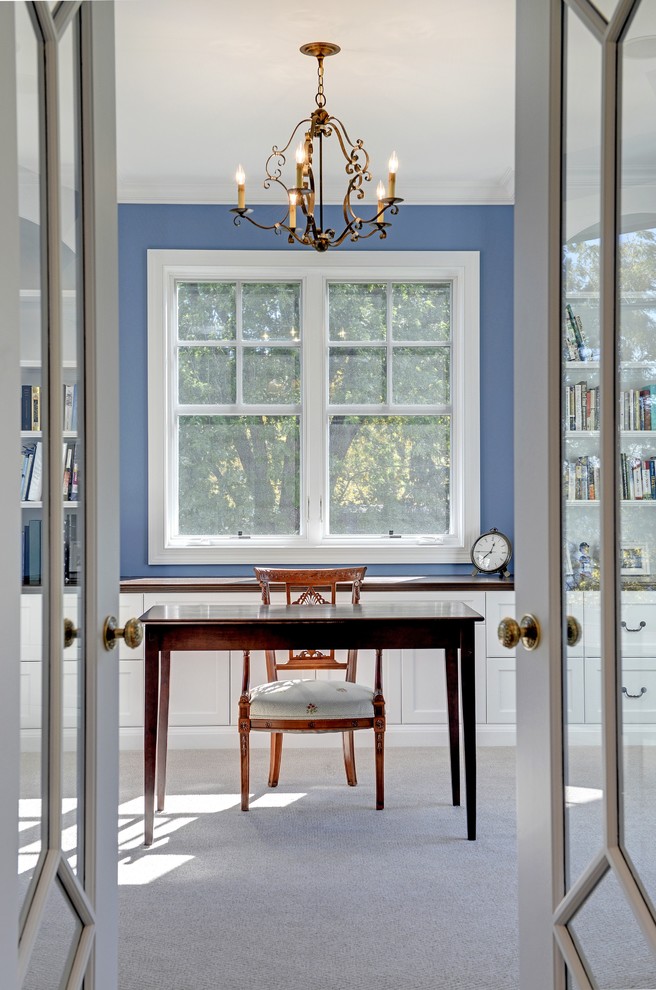 Klassisches Arbeitszimmer mit blauer Wandfarbe, Teppichboden und freistehendem Schreibtisch in Minneapolis