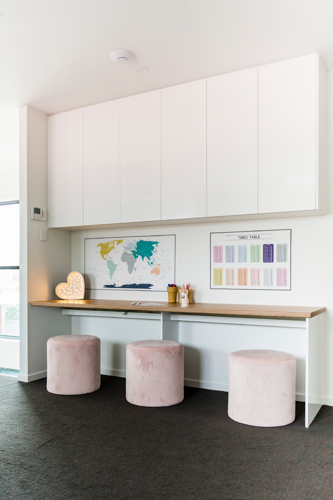 Idee per un ufficio minimal con pareti bianche, moquette, scrivania incassata e pavimento grigio