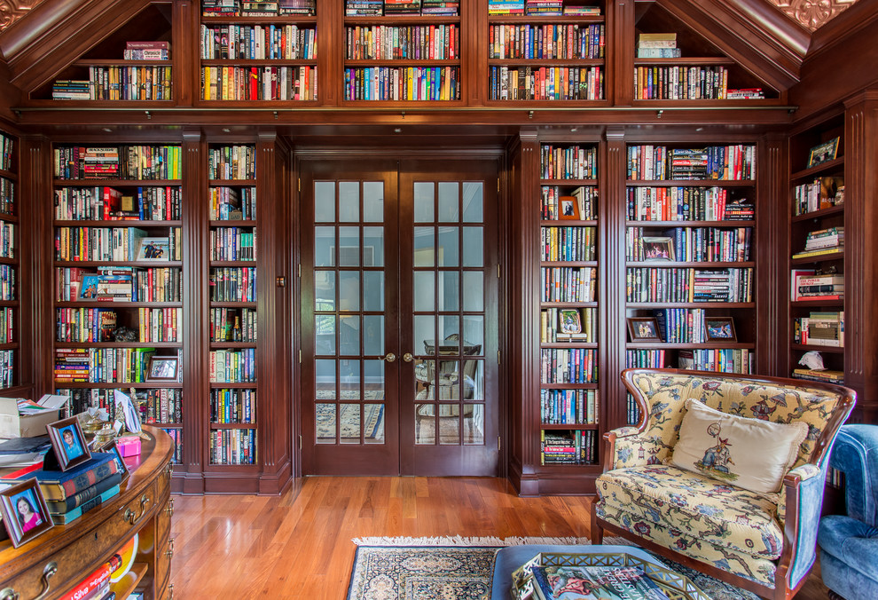 Foto de despacho tradicional grande sin chimenea con suelo de madera en tonos medios y biblioteca