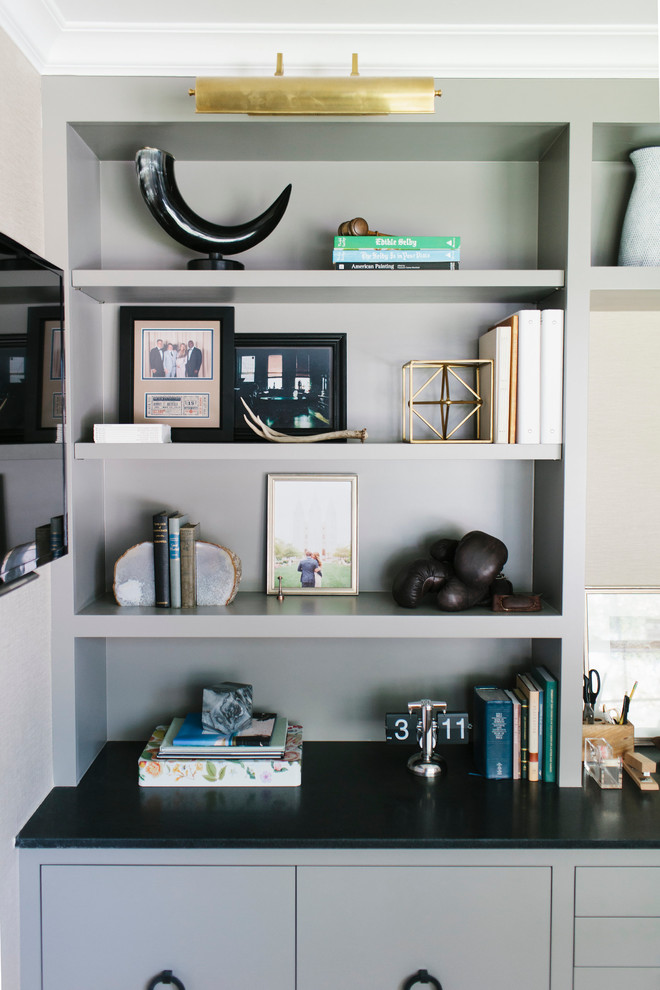 Immagine di uno studio minimalista con pareti beige, parquet scuro e scrivania incassata