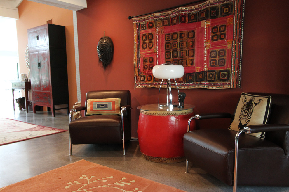オレンジカウンティにあるエクレクティックスタイルのおしゃれな書斎 (赤い壁、コンクリートの床、暖炉なし、自立型机) の写真