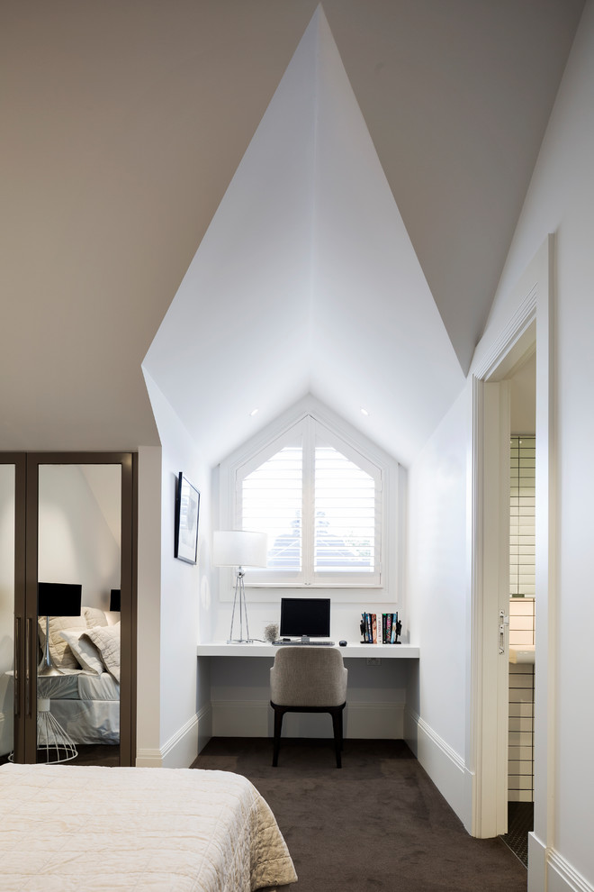 Modern inredning av ett mellanstort arbetsrum, med vita väggar, heltäckningsmatta, grått golv och ett inbyggt skrivbord