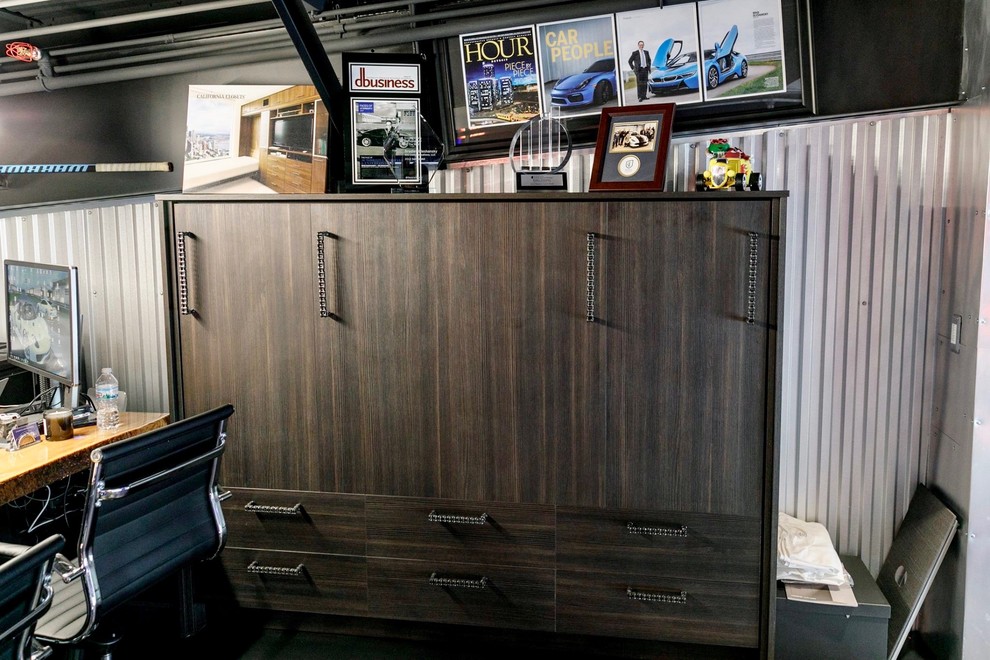 Foto på ett litet industriellt hemmastudio, med grå väggar, betonggolv, ett fristående skrivbord och svart golv