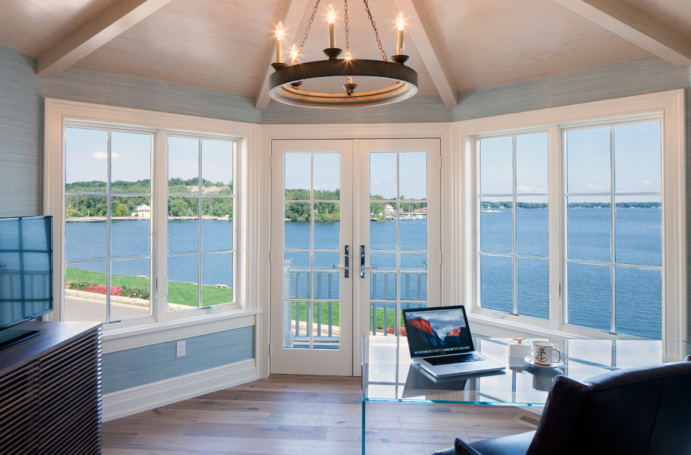 Ispirazione per un ampio ufficio costiero con parquet chiaro, scrivania autoportante, pavimento marrone e pareti blu