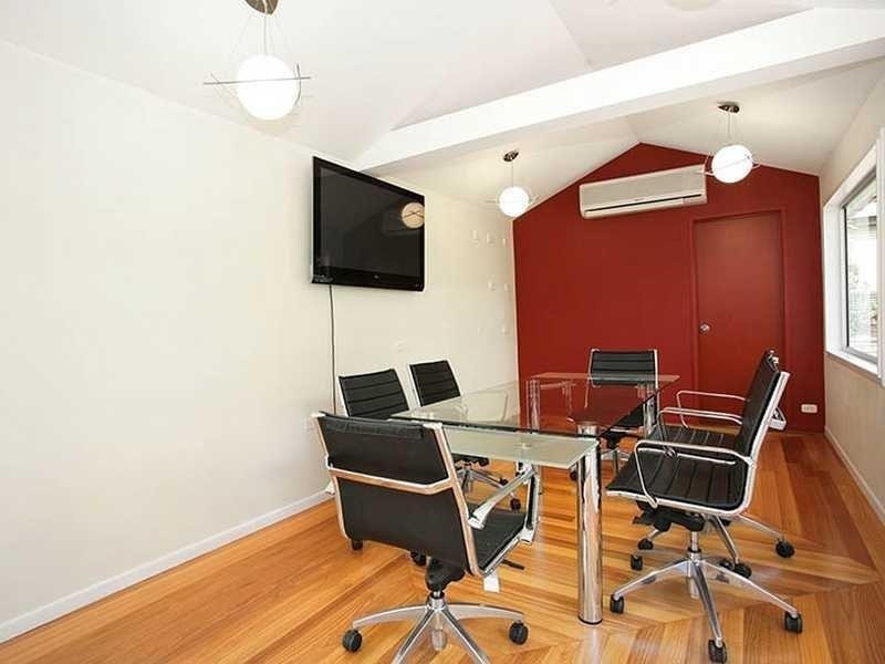 Aménagement d'un grand bureau classique de type studio avec un mur rouge, un sol en bois brun, un bureau indépendant et poutres apparentes.