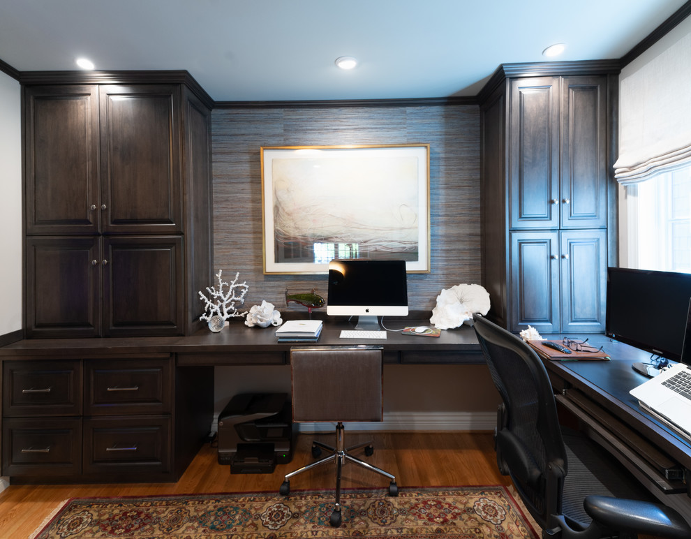 Modelo de estudio clásico de tamaño medio con escritorio empotrado, paredes beige, suelo de madera en tonos medios y suelo marrón