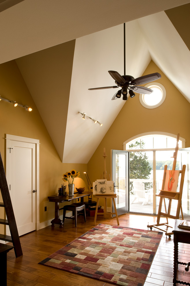 Imagen de estudio de tamaño medio con paredes beige, suelo de madera oscura y escritorio independiente