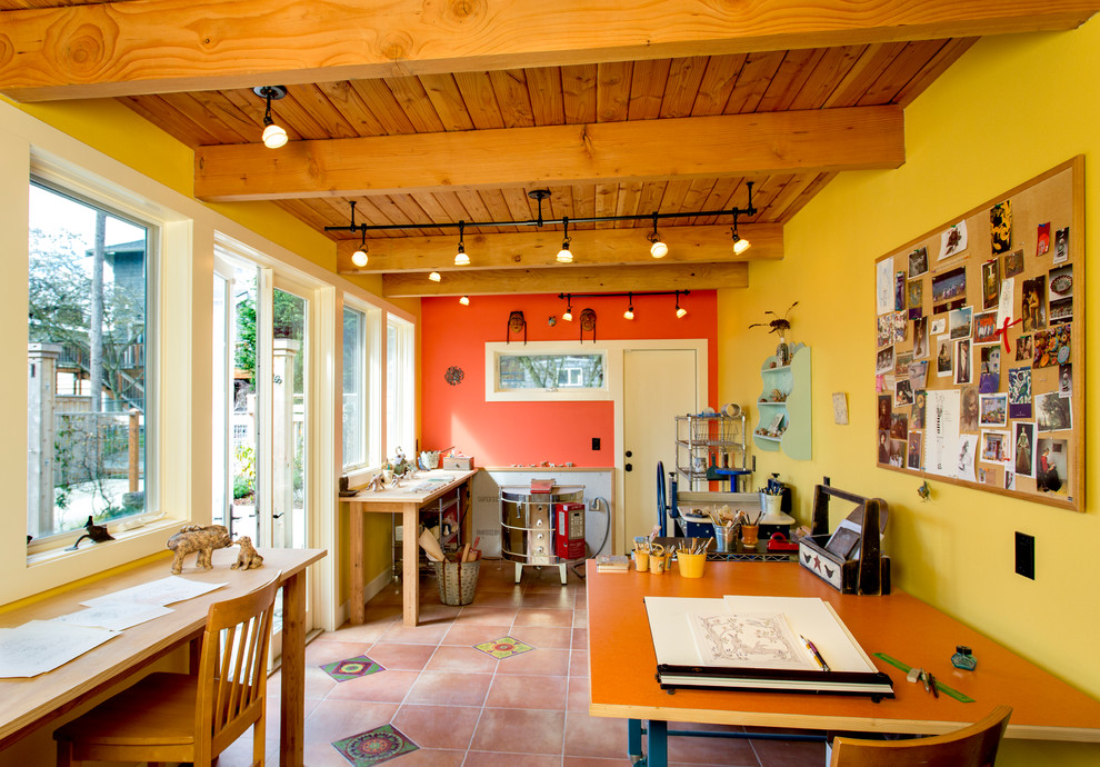 Cette image montre un bureau sud-ouest américain de type studio avec un mur jaune, tomettes au sol et un bureau indépendant.