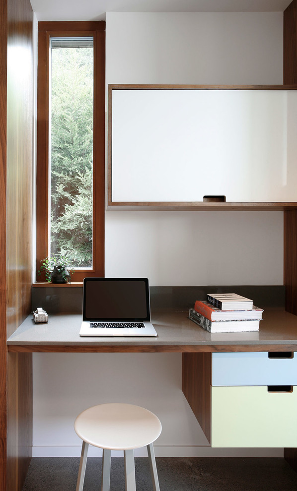 На фото: рабочее место в современном стиле с белыми стенами и встроенным рабочим столом