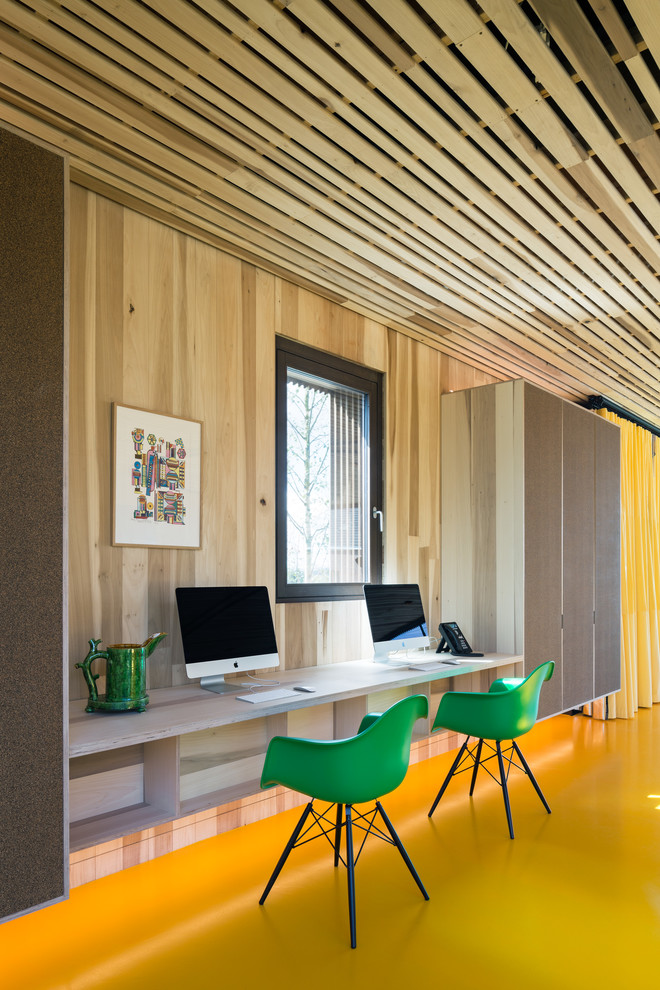 Cette image montre un bureau bohème de taille moyenne avec un mur marron, un sol en linoléum, un bureau intégré et un sol jaune.