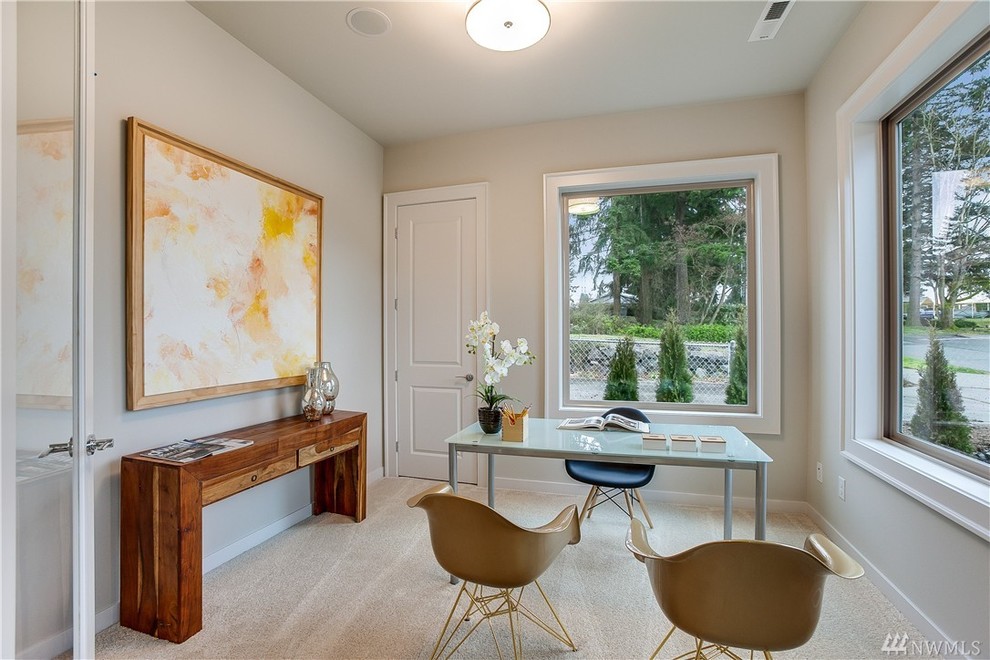 This is an example of a contemporary study in Seattle with carpet and a freestanding desk.