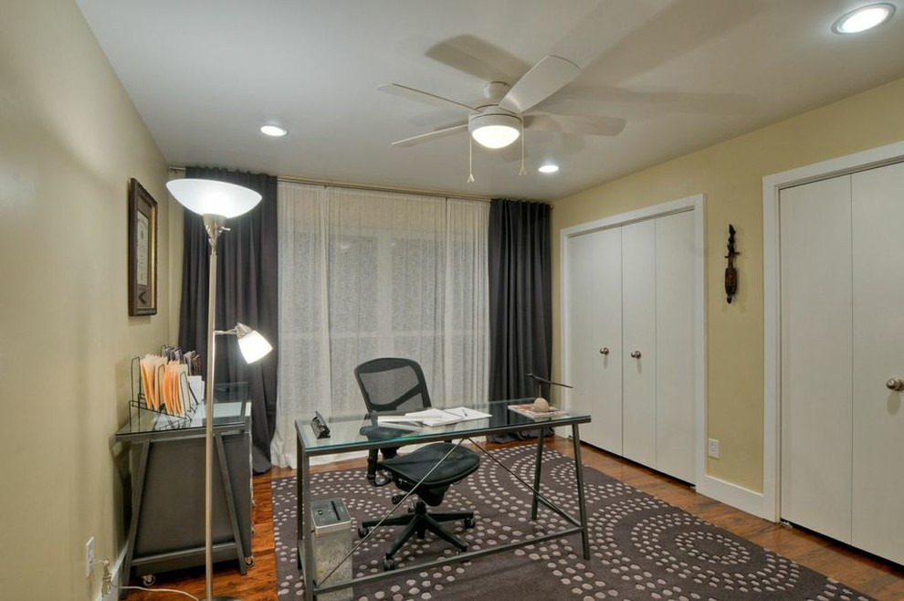 Foto på ett mellanstort funkis arbetsrum, med beige väggar, mellanmörkt trägolv och ett fristående skrivbord