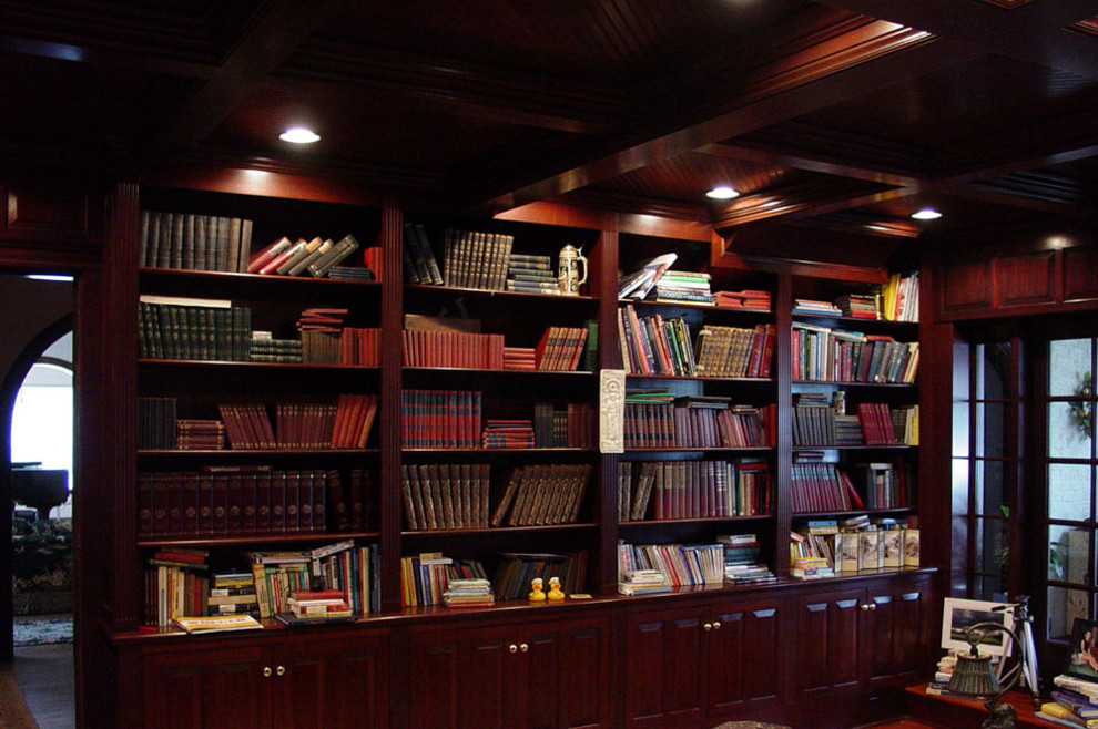 Esempio di uno studio classico di medie dimensioni con libreria, camino classico, cornice del camino in pietra e scrivania autoportante