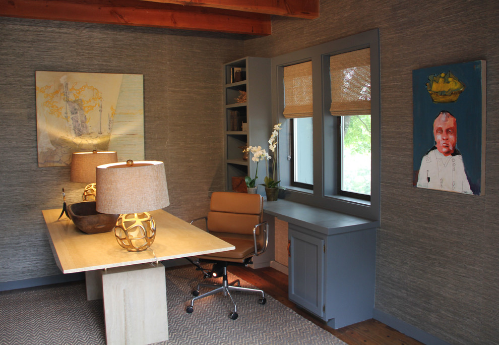 Cette photo montre un bureau tendance de taille moyenne avec un sol en bois brun, aucune cheminée, un bureau indépendant et un mur gris.