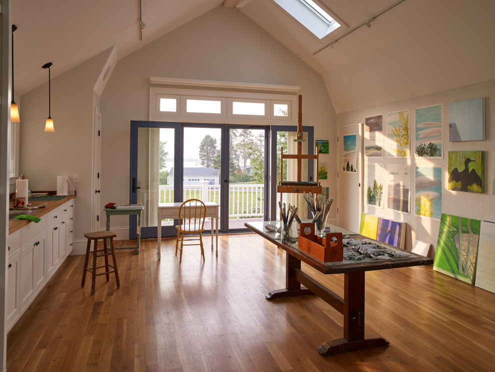 Cette image montre un grand bureau atelier traditionnel avec un mur blanc, un sol en bois brun, un bureau indépendant et aucune cheminée.