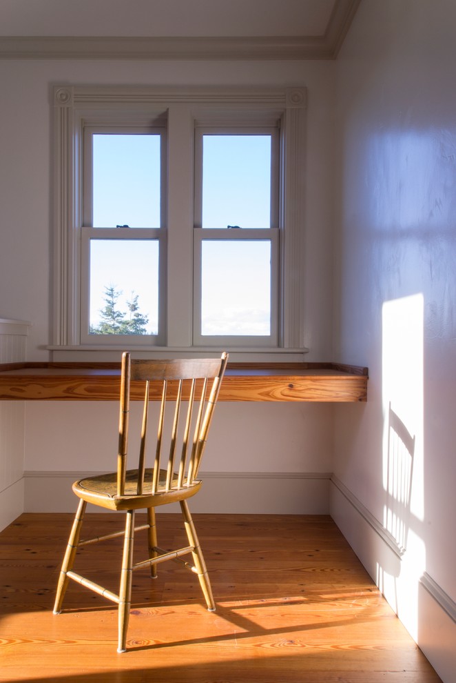 Foto de despacho de estilo de casa de campo pequeño con paredes blancas, suelo de madera en tonos medios y escritorio empotrado