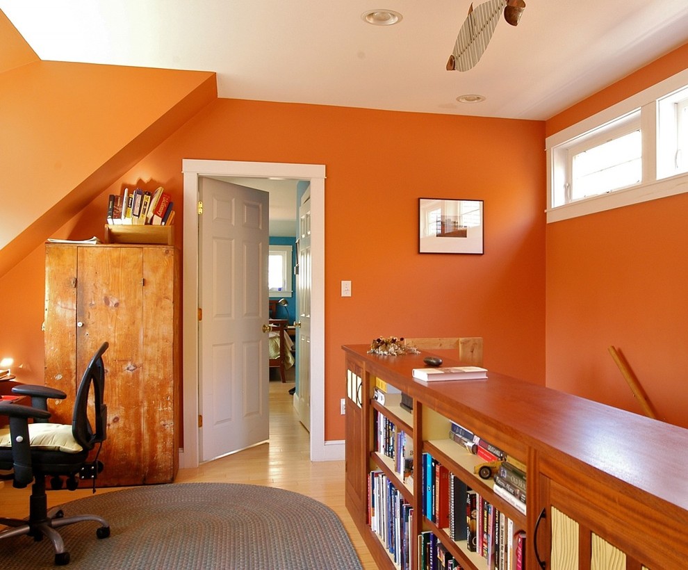 Inspiration pour un bureau bohème de taille moyenne avec un mur orange, un sol en bois brun, un bureau intégré, aucune cheminée et un sol marron.